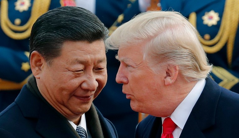 In this Nov. 9, 2017, file photo, U.S. President Donald Trump, right, chats with Chinese President Xi Jinping during a welcome ceremony at the Great Hall of the People in Beijing. 
