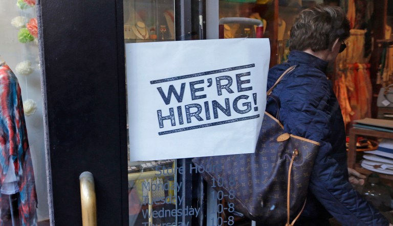FILE - In this Wednesday, May 18, 2016, file photo, a woman passes a "We're Hiring!" sign while entering a clothing store in the Downtown Crossing of Boston. On Wednesday, Sept. 7, 2016, the Labor Department reports on job openings and labor turnover for July.