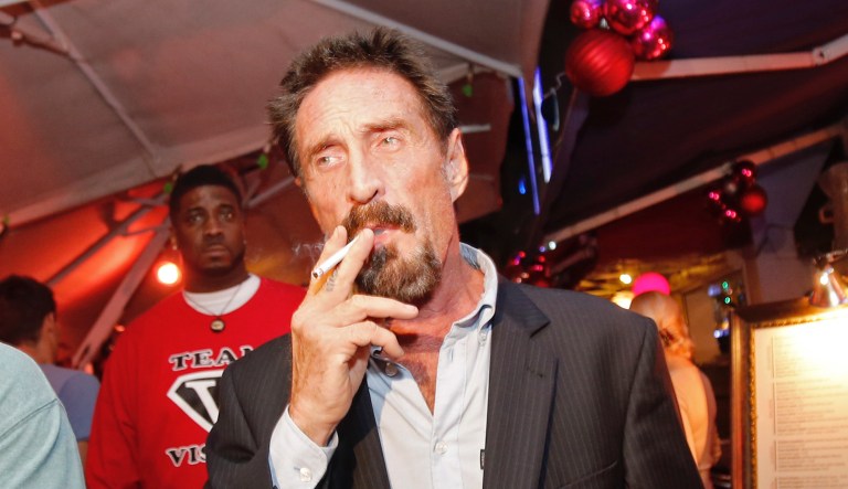 Anti-virus software founder John McAfee smokes a cigarette as he walks on Ocean Drive in the South Beach area of Miami Beach, Fla., on his way to dinner Wednesday, Dec. 12, 2012.