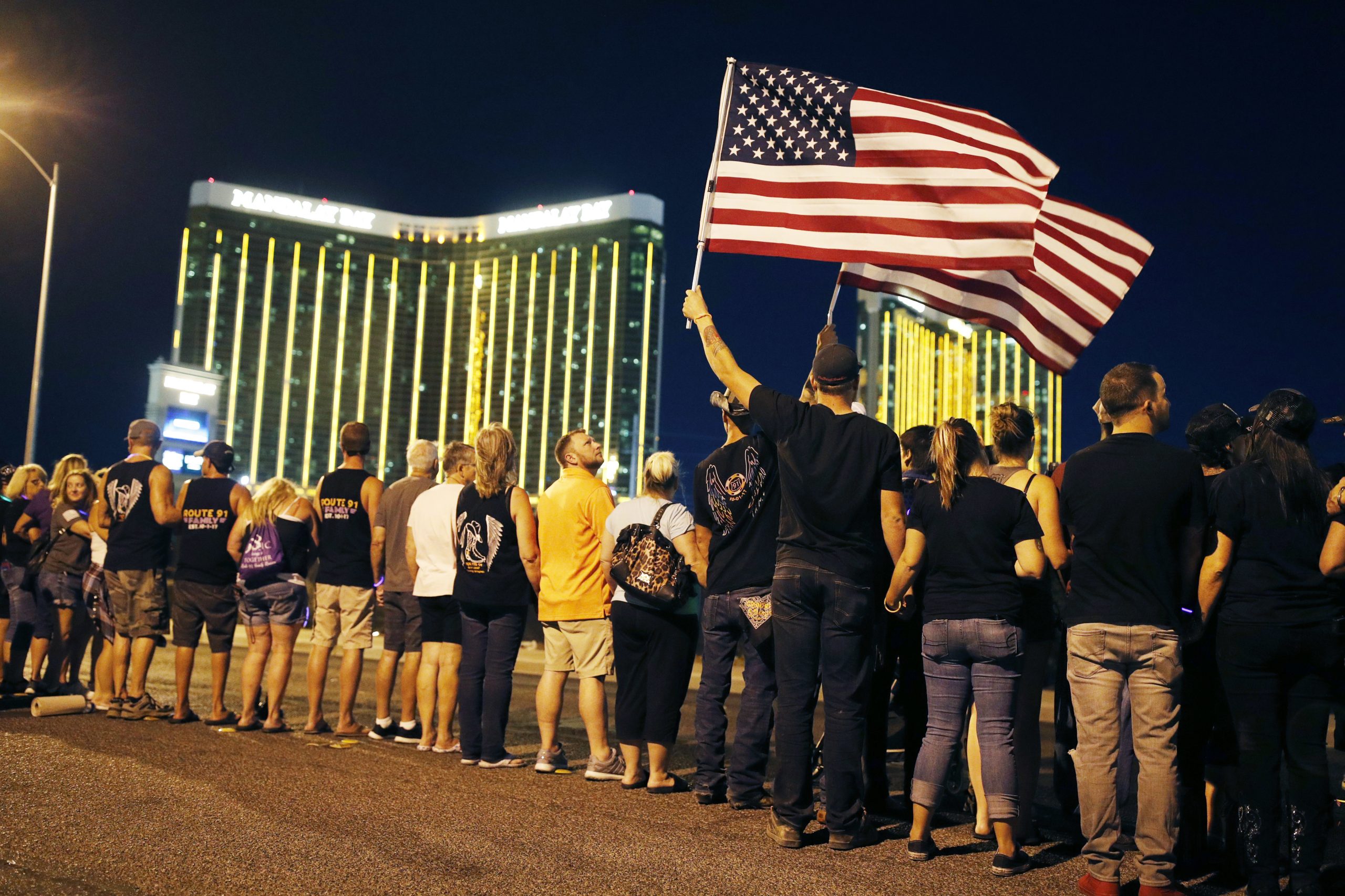 People form a human chain around the shuttered site of a country music festival where a gunman opened fire on the first anniversary of the mass shooting, Monday, in Las Vegas. As people were linking arms and holding hands Monday night near the concert site, officials and several hundred others across town listened to bagpipes and the names of the 58 victims being read aloud.