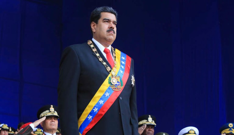 In this photo provided by the Miraflores Presidential Palace, President Nicolas Maduro stands at attention during a event marking the 81st anniversary of the National Guard, in Caracas, Venezuela, Saturday, August 4, 2019. Venezuela's government says several explosions heard at a military event were an attempted attack on President Maduro. Information Minister Jorge Rodriguez said in a live broadcast that several drone-like devices with explosives detonated near the president. He said Maduro is safe and unharmed but that seven people were injured.