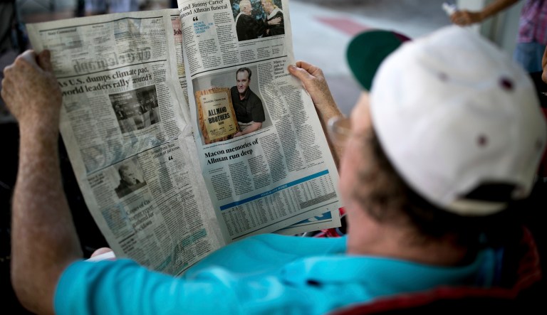 Dwayne Lewis reads a local newspaper covering the death of Gregg Allman, Saturday, June 3, 2017, in Macon, Ga.