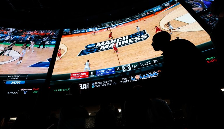 People wait in line to bet on the NCAA college basketball tournament at the Westgate Superbook sports book Thursday, March 15, 2018, in Las Vegas.