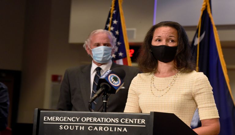 South Carolina Gov. Henry McMaster, left, looks on as state epidemiologist Linda Bell, right, speaks during a COVID-19 briefing on Wednesday, July 29, 2020, in West Columbia, S.C. As of Monday, McMaster says all businesses will be allowed to be open, as long as they adhere to social distancing and capacity limits.