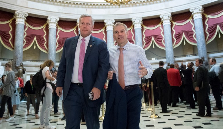 Rep. Mark Meadows, R-N.C., chairman of the conservative House Freedom Caucus, and Rep. Jim Jordan, R-Ohio, a key member of the group, walk through Statuary Hall at the Capitol in Washington, Wednesday, Sept. 13, 2017.