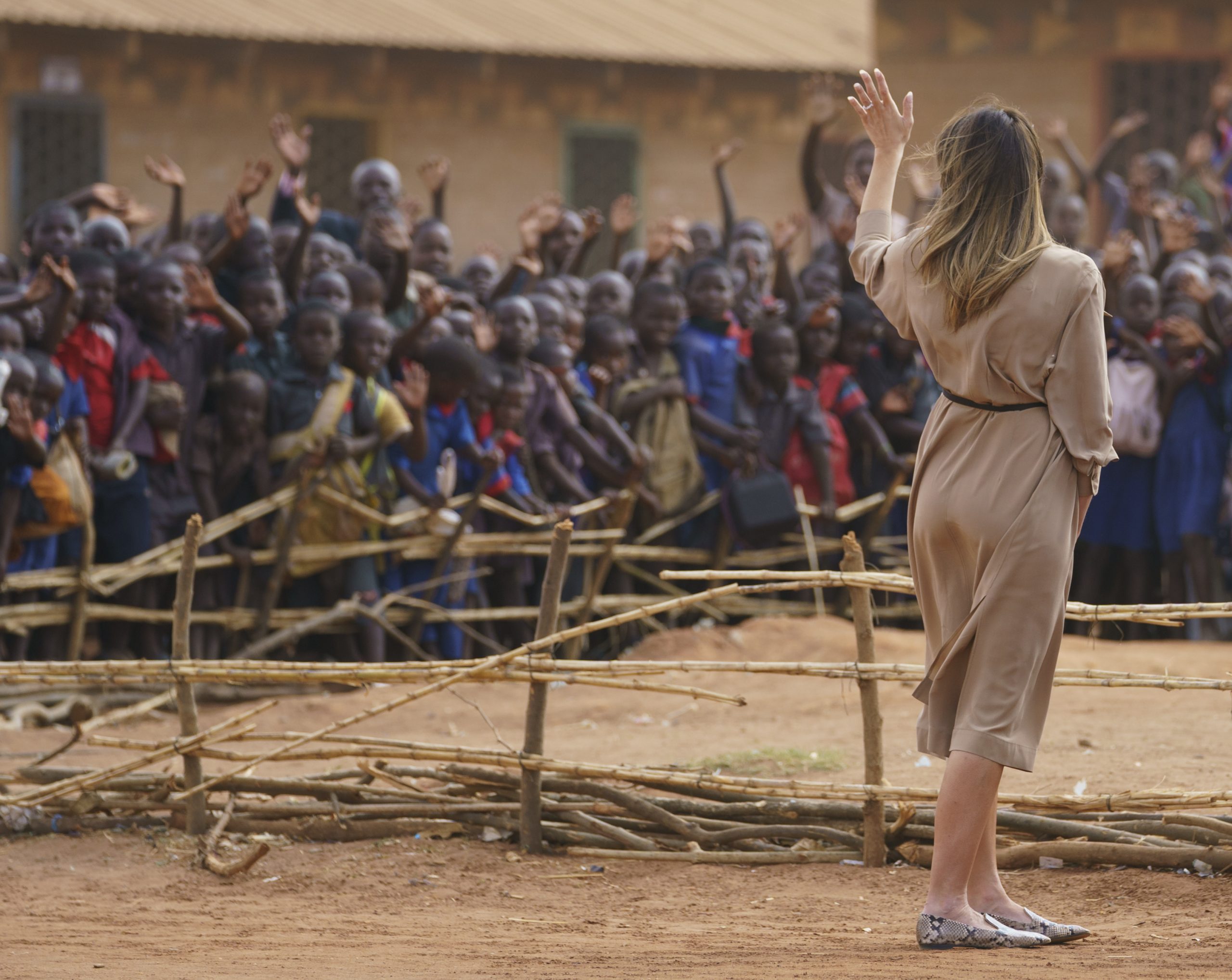 First lady Melania Trump waves to children and others as she visits Chipala Primary School, in Lilongwe, Malawi, on Thursday. Mrs. Trump is visiting Africa on her first big solo international trip, aiming to make child well-being the focus of a five-day, four-country tour. 