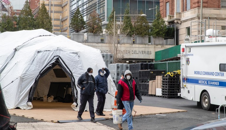 Personnel and construction workers are seen at the site of a makeshift morgue being built in New York.