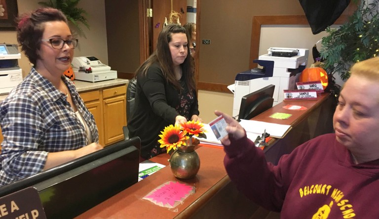 In this Oct. 24, 2018, file photo, Delaine Belgarde, right, shows the new Turtle Mountain Band of Chippewa identification card she received free of charge, in Belcourt, N.D.