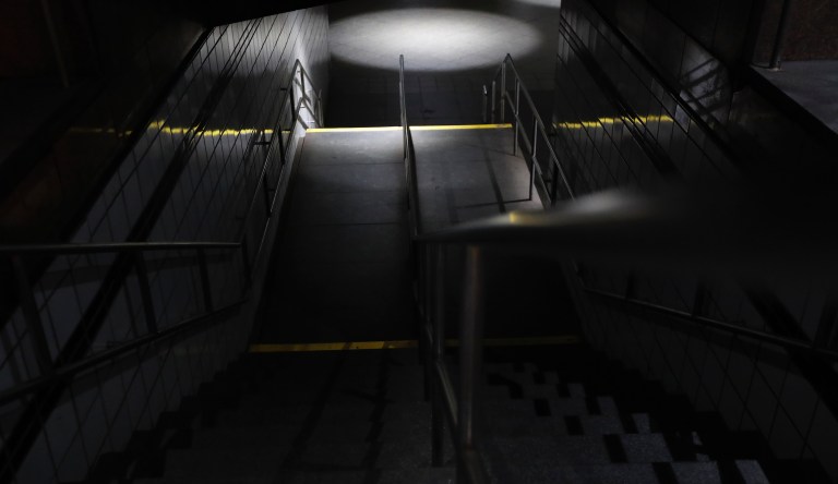 Stairs leading down to the C and E trains at the 50th Street Subway Station are dimly lit during a power outage, Saturday, July 13, 2019, in New York.