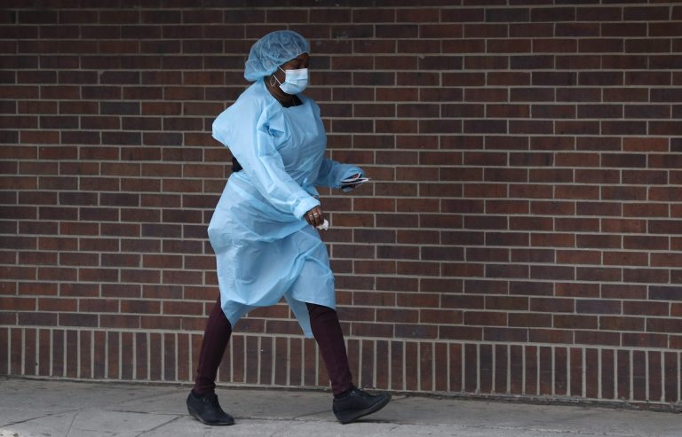 A nurse wearing personal protective equipment (PPE) walks toward the emergency room door, Sunday, April 5, 2020, at Brooklyn Hospital Center in New York. Located in downtown Brooklyn, the public hospital is one of several in New York city treating high numbers of coronavirus cases during the current viral pandemic. The new coronavirus causes mild or moderate symptoms for most people, but for some, especially older adults and people with existing health problems, it can cause more severe illness or death.