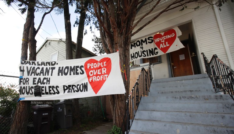 Signs are posted outside of a house that was occupied by homeless women in Oakland, Calif., Tuesday, Jan. 14, 2020.