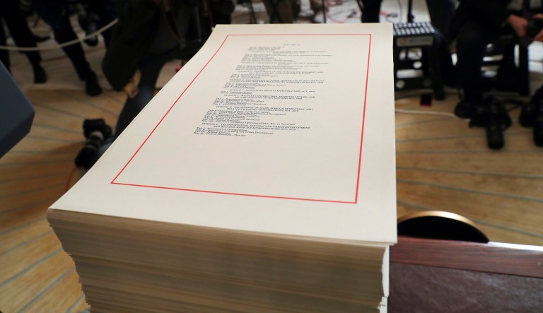 In this March 23, 2018, photo, a copy of the $1.3 trillion spending bill is stacked on a table in the Diplomatic Room of the White House in Washington. Under President Barack Obama and a GOP-controlled Congress, Capitol Hill Democrats had to scratch and claw for months to get tiny increases for domestic programs, but they got almost everything they wanted under a GOP Congress and President Donald Trump.