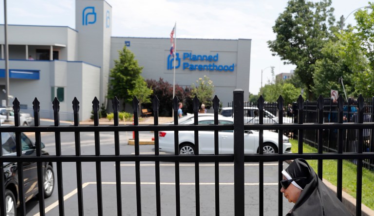 Sister Benedicta, a Carmelite nun, stands at a gate outside the Planned Parenthood clinic in St. Louis during an anti-abortion rally Tuesday, June 4, 2019.