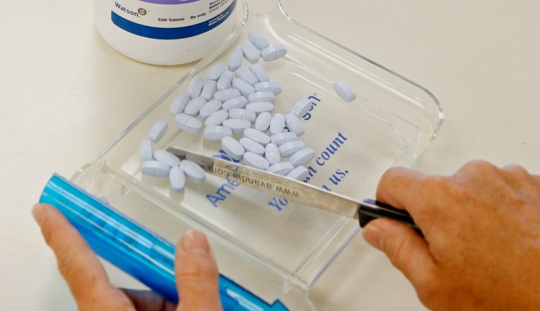 FILE- In this Aug. 5, 2010, file photo, a pharmacy tech poses for a picture with prescription medication at a pharmacy in Edmond, Okla. More than a dozen websites and apps are vying to help U.S. consumers find the lowest prices for prescription drugs by comparing prices and searching for deals, similar to the way Expedia looks for cheap airfare or Bankrate.com looks for low mortgage rates.