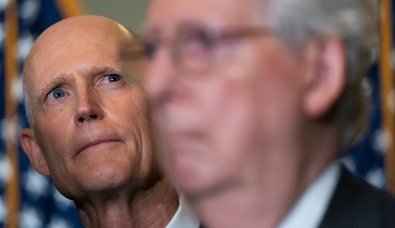 Senate Minority Leader Mitch McConnell of Kentucky and Sen. Rick Scott (R-FL) listen to fellow Republican senators speaks during a news conference.