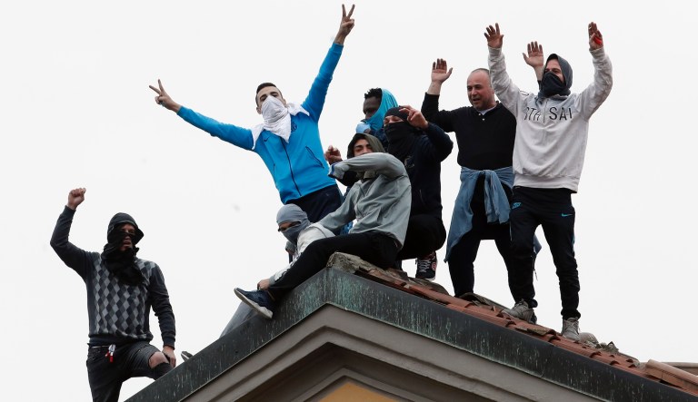 Inmates stage a protest against new rules to cope with coronavirus emergency, atop the roof of the San Vittore prison in Milan, Italy, Monday, March 9, 2020. Italy took a page from Chinaâs playbook Sunday, attempting to lock down 16 million people â more than a quarter of its population â for nearly a month to halt the relentless march of the new coronavirus across Europe.                                