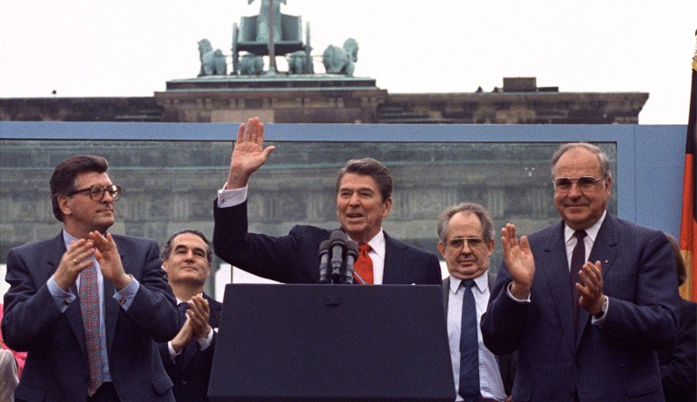 U.S. President Ronald Reagan acknowledges the applause after speaking to an audience in front of the Brandenburg Gate in Berlin on Friday, June 12, 1987.