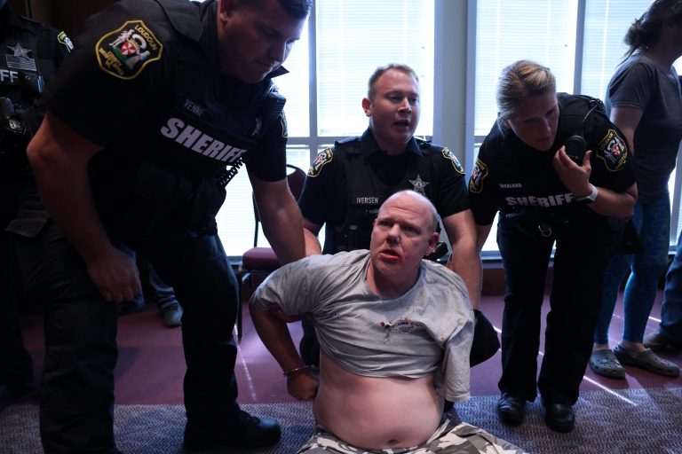Scott Smith is detained after a fight broke out during a Loudoun County School Board meeting which included a discussion of Critical Race Theory and transgender students, in Ashburn, Virginia, on June 22, 2021. 