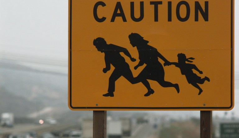 An sign warns motorist of undocumented immigrants crossing Interstate 5, north of San Ysidro Border Crossing,  near San Diego, on Thursday, Aug. 8, 1996. 