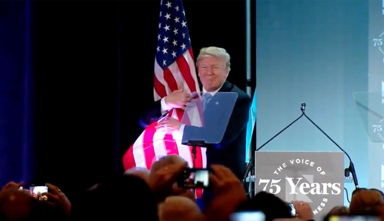Twitter erupts over Trump hugging American flag after speech to business group