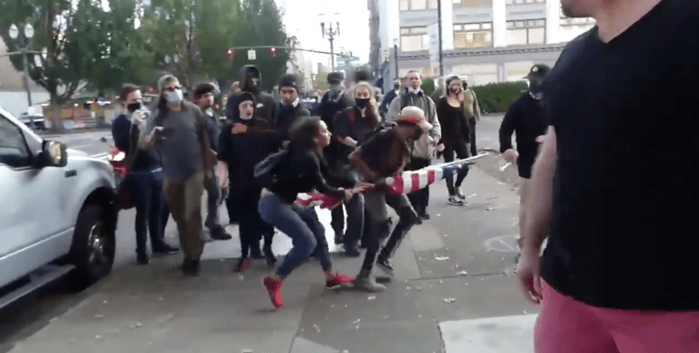 Viral video reportedly shows antifa members trying to rip American flag from woman's hands in Portland