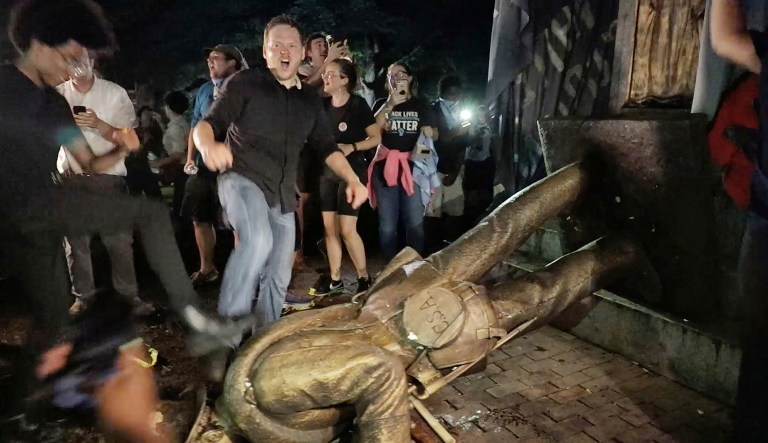 Protesters celebrate after the Confederate statue known as "Silent Sam" was toppled on the campus of the University of North Carolina in Chapel Hill, N.C., Monday, Aug. 20, 2018. 