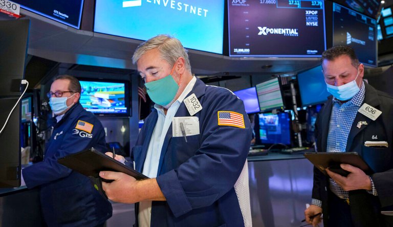 In this photo provided by the New York Stock Exchange, traders Edward McCarthy, center, and Edward Curran, right, work on the floor of the New York Stock Exchange, Monday, Jan. 10, 2022. Stocks fell broadly in afternoon trading on Wall Street Monday and bond yields continued rising as investors anticipate moves by the Federal Reserve to raise interest rates.                         