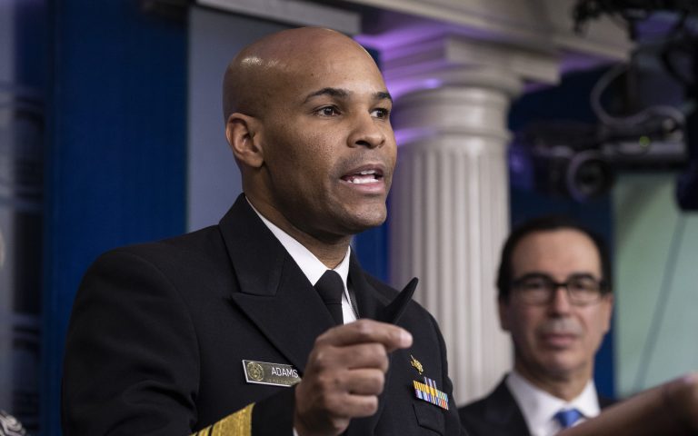 Surgeon General Jerome Adams shows his inhaler as he speaks during a coronavirus task force briefing at the White House, Friday, April 10, 2020, in Washington. President Donald Trump listens at left.                                                                                                                   
