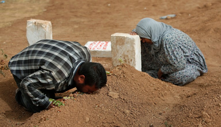 FILE - In this  Saturday, Oct. 11, 2014 file photo, Kurdish Rabia Ali, right, accompanied by her son Ali Mehmud, mourn at the grave of her son Seydo Mehmud 'Curo' , a Kurdish fighter, who was killed in the fighting with the militants of the Islamic State group in Kobani, Syria, and was buried at a cemetery in Suruc, Turkey.