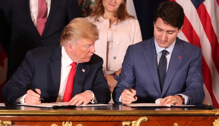 President Trump looks over at Canada's Prime Minister Justin Trudeau's document as they and Mexico's President Enrique Pena Nieto sign a new United States-Mexico-Canada Agreement during a ceremony before the start of the G-20 summit in Buenos Aires, Argentina, Friday, Nov. 30, 2018.