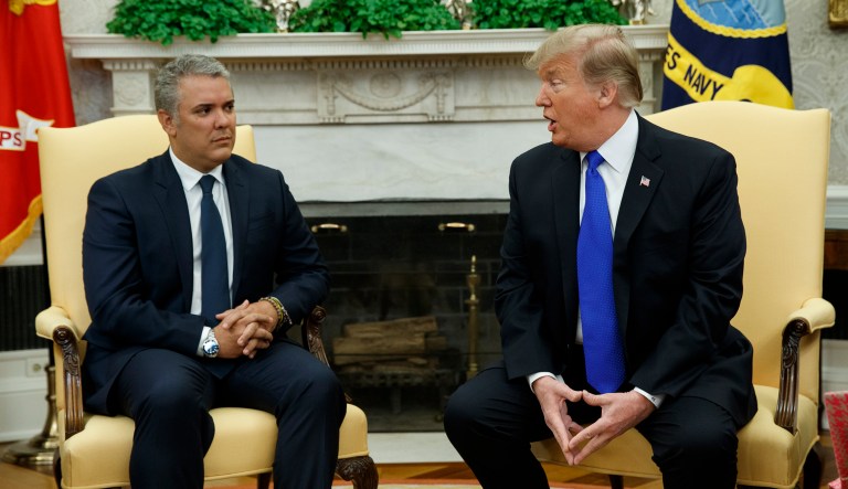 Colombian President Ivan Duque listens as President Donald Trump speaks during a meeting in the Oval Office of the White House, Wednesday, Feb. 13, 2019, in Washington.