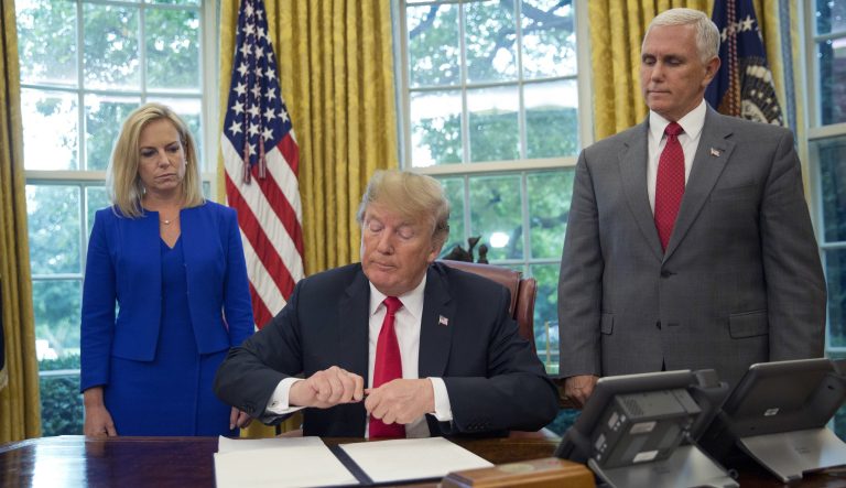 President Trump signs an executive order in the Oval Office of the White House, June 20, 2018. 