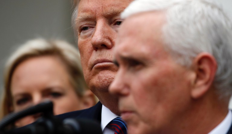 President Trump and Vice President Mike Pence smile as former basketball coach Bob Knight speaks to a crowd at a campaign rally at Southport High School on Friday in Indianapolis.
