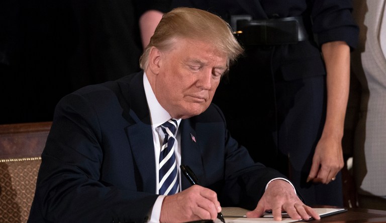 President Donald Trump signs an executive order in the East Room of the White House in Washington, Wednesday, May 9, 2018, during an event celebrating military mothers and spouses. The executive order addresses military spouse unemployment by providing greater opportunity for military spouses to be considered for federal competitive service positions, and holds agencies accountable for increasing their use of the non-competitive hiring authority for military spouses.