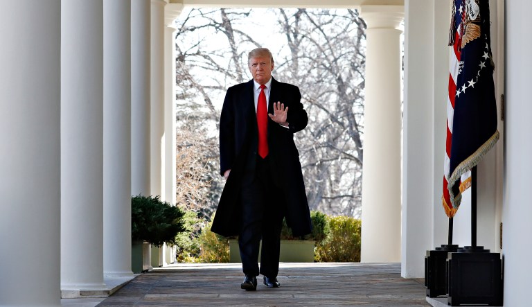 President Donald Trump waves as he walks through the Colonnade from the Oval Office of the White House on arrival to announce a deal to temporarily reopen the government, Friday, Jan. 25, 2019, from the Rose Garden of the White House in Washington.