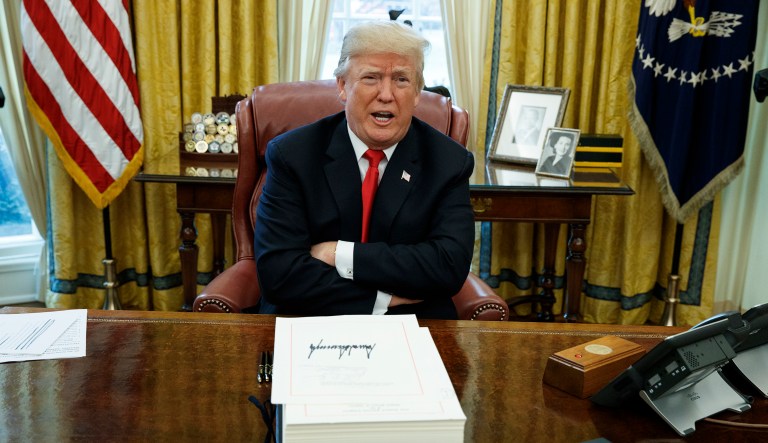FILE - In this Dec. 22, 2017, file photo, President Donald Trump speaks with reporters after signing the tax bill and continuing resolution to fund the government, in the Oval Office of the White House in Washington.