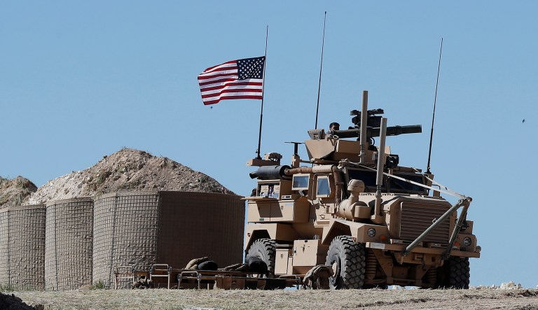 A U.S. soldier sits on an armored vehicle on a newly installed position, near the tense front line between the U.S-backed Syrian Manbij Military Council and the Turkish-backed fighters, in Manbij, north Syria, Wednesday, April 4, 2018. A week ago, there was just a single house where U.S. soldiers had hoisted a U.S. flag on a hill a little ways back from a tense front line in Syria. Now on Wednesday stood a growing outpost with a perimeter of large sand barriers and barbed wire, a new watch tower and half a dozen armored vehicles, The Associated Press found.
