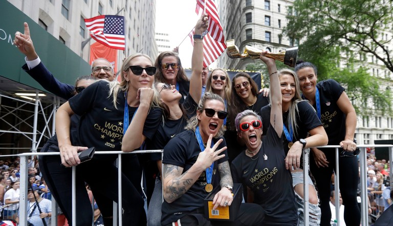 Megan Rapinoe holds the Women's World Cup trophy as the U.S. women's soccer team is celebrated with a parade along the Canyon of Heroes, Wednesday, July 10, 2019, in New York.