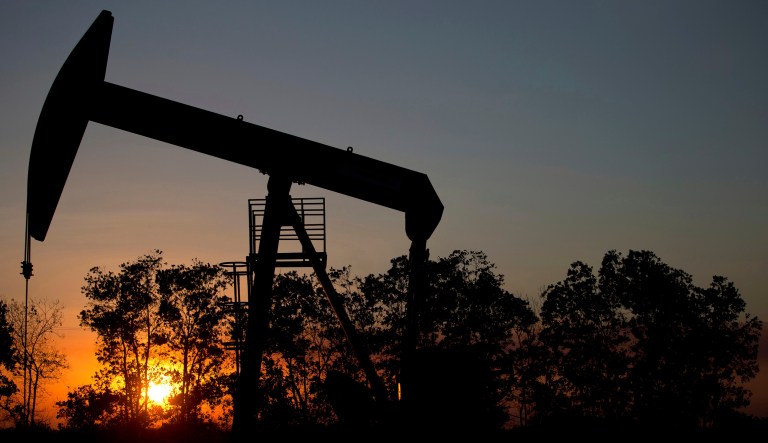 In this Feb. 19, 2015 file photo, the sun sets behind an oil well in a field near El Tigre, Venezuela.