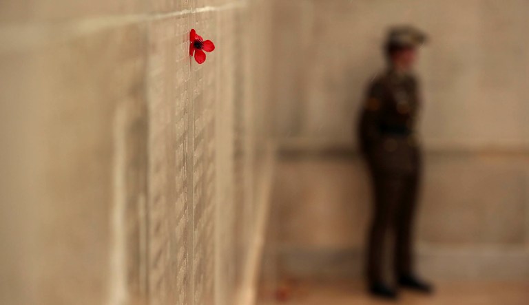 An Australian soldier stands near to a poppy attached to the wall of the missing soldiers during an Armistice ceremony marking 100 years since the end of the World War I at the Australian National Memorial in Villers-Bretonneux, France, Sunday, Nov. 11, 2018.