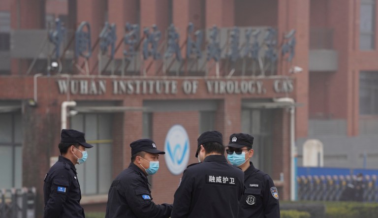 Security personnel gather near the entrance of the Wuhan Institute of Virology during a visit by the World Health Organization team in Wuhan in China's Hubei province on Feb. 3, 2021.