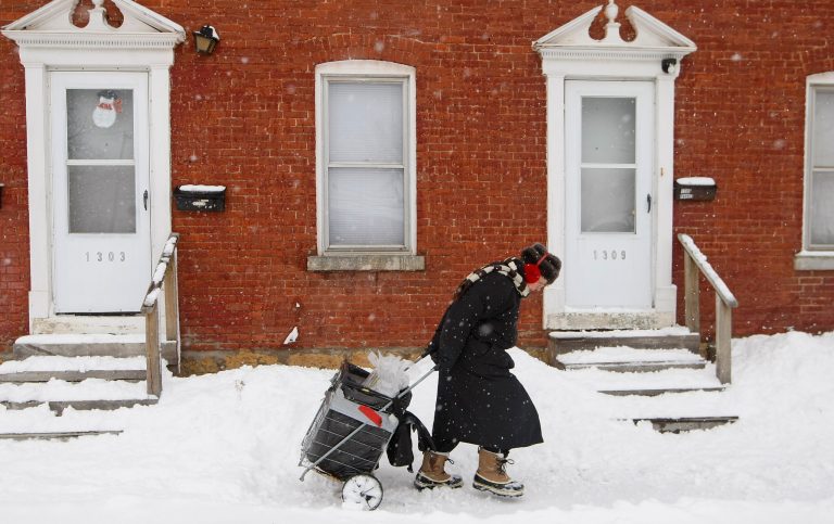 Pat Beals fights her way through blowing snow while delivering shoppers in Dubuque, Iowa, Wednesday Feb. 27, 2013. The Dubuque area was hit last night with a winter storm dumping snow across the tristate area. (AP Photo/The Telegraph Herald, Jeremy Portje)