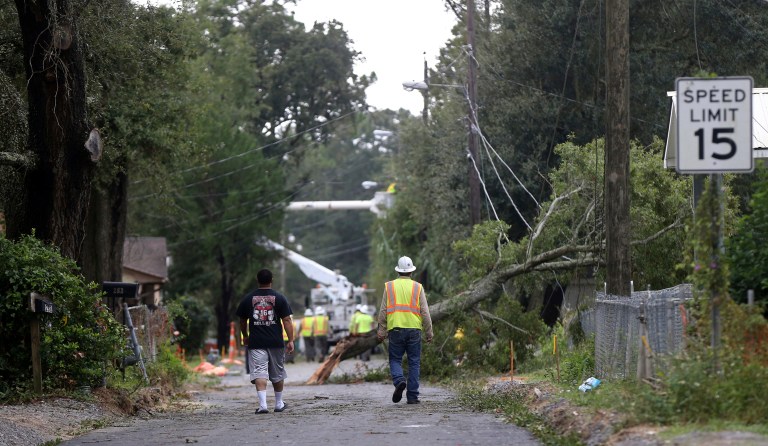 Workers clear trees from power lines in Biloxi, Miss., in the aftermath of Hurricane Nate, Sunday, Oct. 8, 2017. (AP Photo/Gerald Herbert)