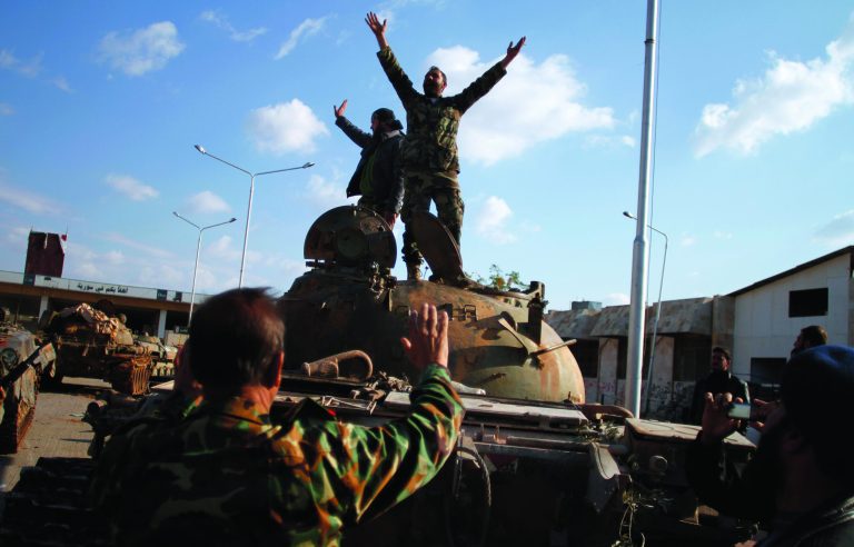 Syrian fighters celebrate the victory on top of a tank they took after storming a military base in Aleppo, Monday, Nov. 19, 2012. (AP Photo/ Khalil Hamra)