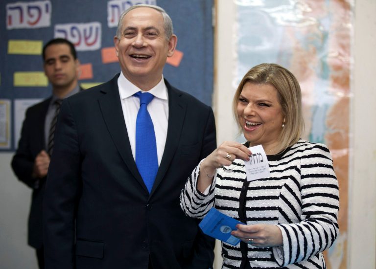 FILE - In this Tuesday, Jan. 22, 2013 file photo, Israeli Prime Minister Benjamin Netanyahu stands by his wife Sara as she casts her ballot at a polling station in Jerusalem. As his government is slashing welfare benefits and hiking takes for the working class to overcome a huge deficit, Israeli Prime Minister Benjamin Netanyahu is finding himself under fire again for his lavish lifestyle. (AP Photo/Uriel Sinai, File)