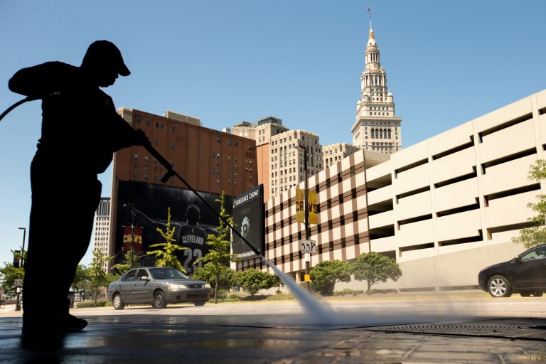 A worker cleans the sidewalk in Cleveland. The Labor Department releases its job openings and labor turnover survey for July on Wednesday. (AP Photo/Andrew Harnik)