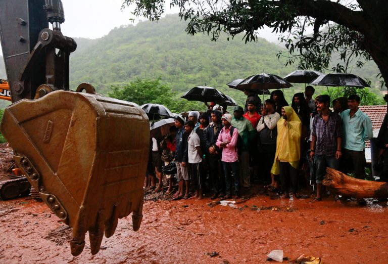 Indian villagers watch rescue operations at the site of a massive landslide in Malin village in Pune district of western Maharashtra state, India, Thursday, July 31, 2014. Two days of torrential rains triggered the landslide early Wednesday, killing more than two dozen people and trapping more than 150, authorities said. (AP Photo/Rafiq Maqbool)