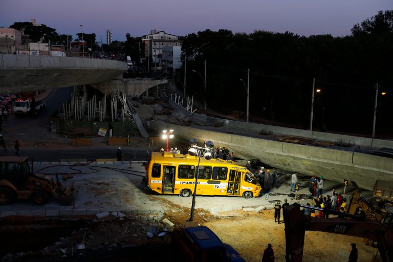 A bus sits damaged next to a bridge after it collapsed in Belo Horizonte, Brazil, Thursday, July 3, 2014. The overpass under construction collapsed Thursday in the Brazilian World Cup host city. The incident took place on a main avenue, the expansion of which was part of the World Cup infrastructure plan but, like most urban mobility projects related to the Cup, was not finished on time for the event. (AP Photo/Victor R. Caivano)