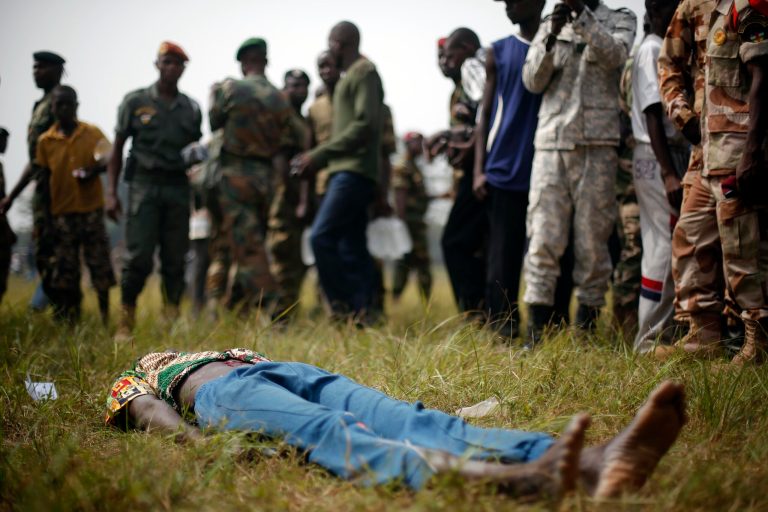 A man suspected to be a Muslim Seleka militiaman lays wounded after being stabbed by newly enlisted FACA (Central African Armed Forces) soldiers moments after Central African Republic Interim President Catherine Samba-Panza addressed the troops in Bangui Wednesday Feb. 5, 2014. The man died later after being lynched by hundreds of recruits using knifes, bricks and foot blows to the head. (AP Photo/Jerome Delay)