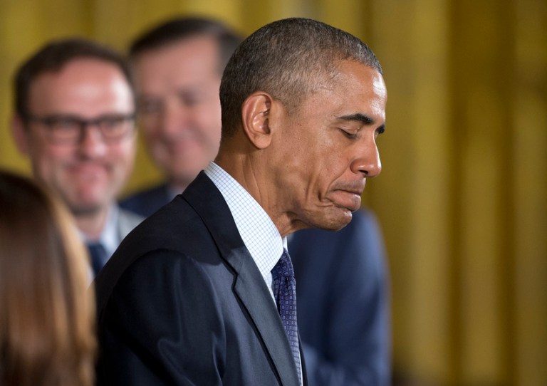 President Barack Obama pauses as he speaks during a ceremony in the East Room of the White House in Washington, Monday, Jan. 16, 2017, where the president honored the 2016 World Series Champion Chicago Cubs baseball team. In the background are Chicago Cubs Chairman Tom Ricketts, center, and his brother Todd Ricketts, who was chosen by President-elect Donald Trump to be Deputy Commerce Secretary. (AP Photo/Carolyn Kaster)